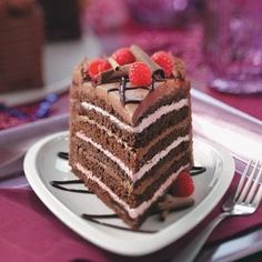 a slice of chocolate cake with raspberries on top