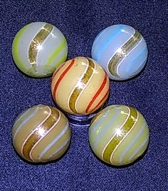 four glass marbles sitting on top of a blue surface