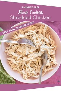 a white bowl filled with shredded chicken on top of a purple table cloth next to a fork and knife