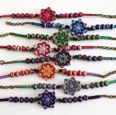 a bunch of beaded necklaces are arranged on a white surface with beads and chains