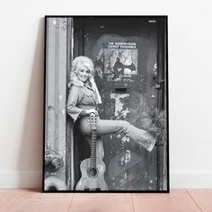 a black and white photo of a woman leaning on a door with her legs up