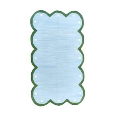 a blue and green rug with white polka dots on the bottom, in front of a white background