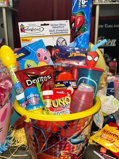 a basket filled with candy and snacks on top of a table next to other items