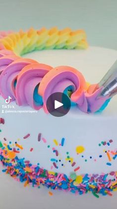 a white cake with sprinkles and a knife sticking out of the icing