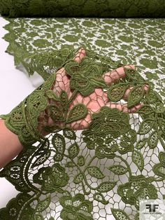 a woman's hand with green lace on it