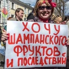 a woman holding up a sign in front of a crowd