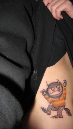 a person with a small tattoo on their stomach that has an angry cat drawn on it