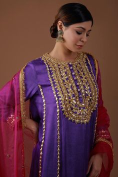 Royal amethyst kurta with gota, sparkling sequin, lustrous pearl, nakshi embellishment in geometric pattern on yoke. Paired with pleated salwar and regal red dupatta.
Components: 3
Pattern: Embellishment
Type Of Work: Gota, sequin, pearl, nakshi
Neckline: Notched
Sleeve Type: Long sleeves
Fabric: Kurta and Salwar: Mashru Silk, Dupatta: Organza
Color: Purple
Other Details: 
Fringe border
Contrast dupatta
Embroidery on salwar hem
Model height: 5ft 7inches, wearing size M
Occasion: Sangeet - Aza Fa Purple Kurta For Festive Occasions, Purple Zari Work Blouse For Eid, Elegant Purple Kurta For Festivals, Purple Designer Kurta With Mirror Work, Designer Purple Kurta With Mirror Work, Festive Purple Kurta With Dori Work, Bollywood Style Purple Blouse For Eid, Purple Bollywood Blouse For Eid, Elegant Purple Sets For Transitional Season