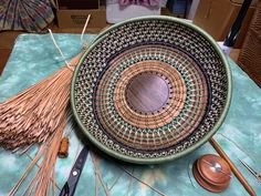 a bowl sitting on top of a table next to a pair of scissors and yarn