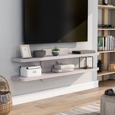 a flat screen tv mounted to the side of a wall in a living room next to a book shelf