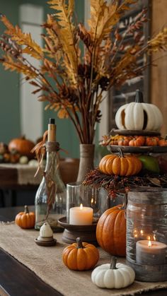 a table topped with lots of pumpkins and candles