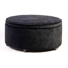 a black round ottoman sitting on top of a white floor