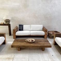 a living room with couches and tables on the floor in front of a wall