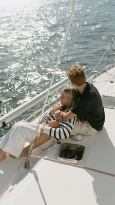 a man and woman sitting on the back of a boat