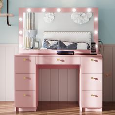 a pink vanity with lights on it in a room