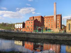 an old brick building next to a body of water