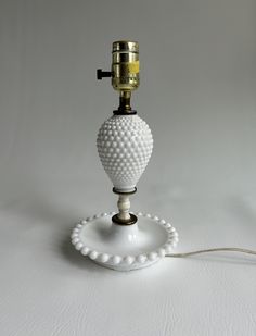 a white table lamp sitting on top of a white surface