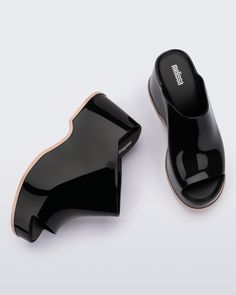 Throwback style meets current trends—that’s just how the Patty rolls. Lightweight and streamlined with a wide strap and a peep toe, these platform mules are true attention seekers, and the contrasting sole detail amps up the cool factor. Made from our revolutionary Melflex® PVC plastic, you enjoy more flexibility and comfort. Plus, they’re 100% recyclable. Chic Platform Slide Slippers, Modern Open Toe Platform Slippers With Deep Heel Cup, Modern Open Toe Platform Slippers, Chic Black Slip-on Platform Slippers, Modern Black Wedge Heel Mules, Chic Platform Slides With Round Toe, Modern Black Platform Slippers With Rubber Sole, Modern Black Mules With Deep Heel Cup, Modern Sandals With Contrast Sole For Summer