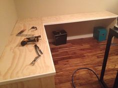 tools are laying on the floor next to a shelf in a room with hard wood floors