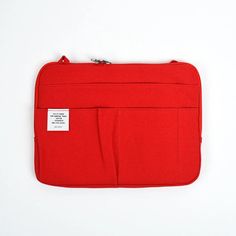 a red laptop case with a white label on the front and side pocket for it