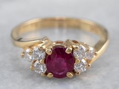 Timeless simplicity! This deeply colored red ruby sits in a simple four-prong setting, crafted of yellow gold. The polished gold really lets the color of the ruby stand out, and the lovely diamond accents add amazing sparkle and elegance to the ring! This could make a great engagement ring, or just as a ring for any occasion! Metal: 14K Yellow Gold Gem: Ruby .74 Carats Gem Measurements: 5.7 x 4.8 mm, Oval Accents: 6 Diamonds totaling .36 Carats, G in Color, VS in Clarity Ring Size: 6 Marks: ".36 Yellow Gold Ruby Ring With Diamond Accents, Ruby Wedding Ring Set, Ruby Ring Designs, Antique Ruby Ring, Gold Ruby Ring, Yellow Gold Sapphire Ring, Ruby Ring Vintage, Timeless Simplicity, Engagement Ring Yellow Gold