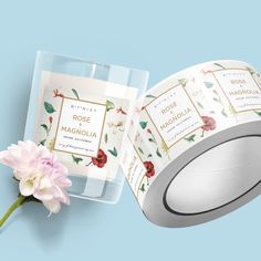 a roll of toilet paper next to a pink flower on a blue background with the words rose and magnolia printed on it