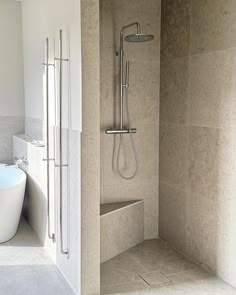 a bathroom with a bathtub, shower head and standup shower in the corner