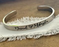 This listing features ONE stainless steel silver, gold, or rose gold cuff bracelet for your daughter or daughter in law.  The outside of the bracelet will come with the bride and groom's names separated with a heart symbol, or a monogram in the script font shown, along with a date on one end and a heart or Love infinity symbol on the other end. The inside of the bracelet will come with a message, personalized if desired.  -->Today God blessed my son with a wife, and me a daughter and friend for Custom Name Stainless Steel Bracelet, Minimalist Stainless Steel Bangle For Anniversary, Minimalist Stainless Steel Anniversary Bangle, Personalized Stainless Steel Jewelry With Custom Text, Silver Name Bracelet For Bridesmaid Gift, Silver Name Bracelets For Bridesmaid Gift, Silver Personalized Bracelets For Bridesmaid Gift, Customized Stainless Steel Name Bracelet For Anniversary, Personalized Stainless Steel Bracelets For Anniversary