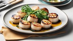 scallops are served on a white plate with mustard sauce and garnish