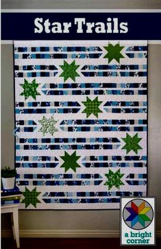 the star trails quilt pattern is displayed in front of a white wall with blue and green stripes