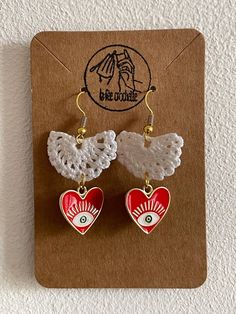 Brightly colored dangling earrings, decorated with a Mexican-style heart, each model is unique, hand-crocheted just for you. Handmade Dangle Heart Earrings For Gift, Handmade Adjustable Drop Heart Earrings, White Dangle Heart Earrings With Ear Wire, Cute Handmade White Heart Earrings, Bohemian White Crochet Earrings, Cute Handmade Heart Dangle Earrings, Cute Handmade Dangle Heart Earrings, Cute Handmade Heart Drop Earrings, Handmade Cute Heart Drop Earrings