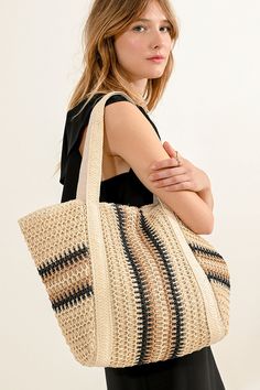 a woman is holding a large woven tote bag