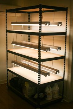 an empty shelving unit is lit up with light from the back lights on it