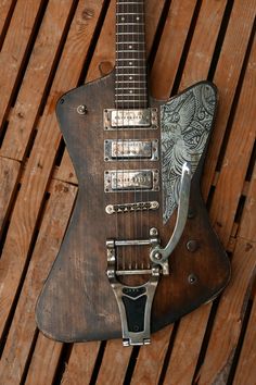 an old guitar is sitting on a wooden table with metal hardware and strings attached to it