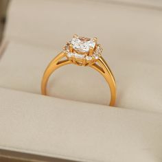 an engagement ring in a box with its lid open showing the center stone and side stones