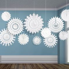 snowflakes hanging from the ceiling in a room with wood flooring and blue walls