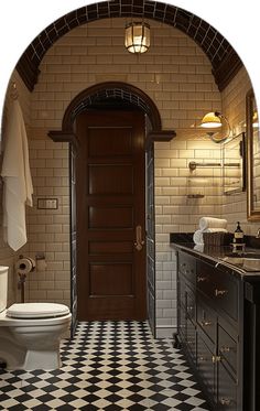 a white toilet sitting in a bathroom next to a black and white checkered floor