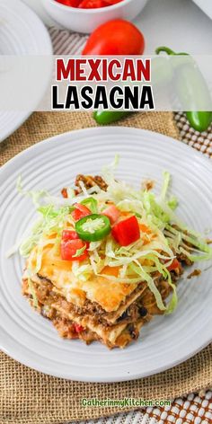 mexican lasagna on a white plate with tomatoes and lettuce