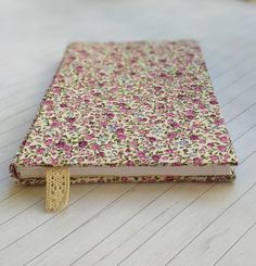 a small notebook covered in pink and yellow flowers