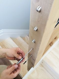 a person is working on something with some tools in their hand and there are screwdrivers next to the door