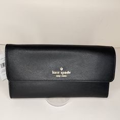 Kate Spade Madison Travel. Wristlet/ Clutch/ Wallet New With Tags Saffiano Leather Color - Black Gold Tone Hardware Metal Monogram Rear Zip Pocket Detachable Wristlet Strap With 6" Drop Snap Closure 12 Card Slots 2 Cash Slots Passport Slot Zip Pocket Really Beautiful! Measures: 8.25" X 4.75" X 1" Kate Spade Black Rectangular Wallet, Kate Spade Black Evening Wallet, Black Bifold Clutch For Travel, Elegant Black Kate Spade Wallet, Kate Spade Black Wallet For Everyday Use, Black Kate Spade Wallet For Everyday Use, Black Wallet With Magnetic Closure, Everyday Black Kate Spade Wallet, Formal Kate Spade Clutch