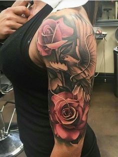 a woman's half sleeve with roses and a bird on the arm, done by person