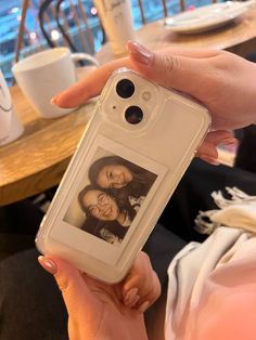 a woman holding up a cell phone case with an image of two women on it