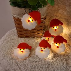 christmas decorations with lights in the shape of santa's hats and beards on a table