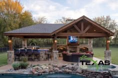 a backyard with a pool, grill and covered patio area next to a fire pit