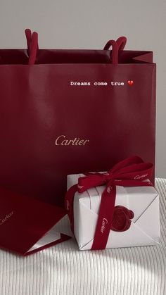 a red bag and white box with a heart on the inside sitting next to each other