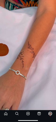 a woman's arm with a tattoo on it and a ring around the wrist