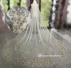 a bridal veil with flowers on it in front of a window and an umbrella