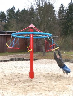 a young child is playing in the sand with a colorful play set on his back