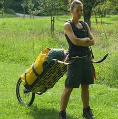 a woman standing next to a bike with a yellow basket on it's back